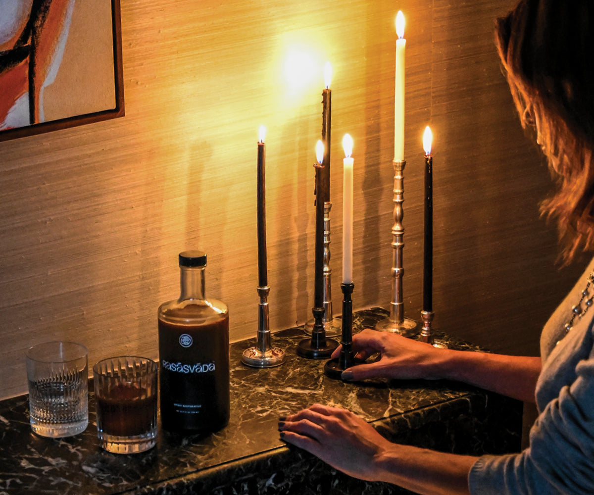 A bottle of Rasasvada and lit candles