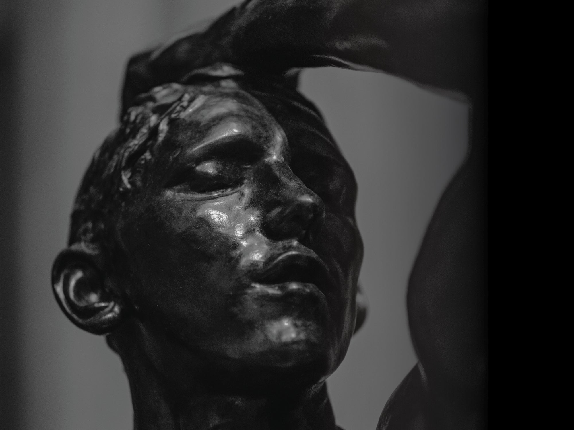 A black and white sculpture showing a man thinking