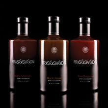 Three bottles of Rasšsvča bitters, each a different color, displayed side by side against a black background.