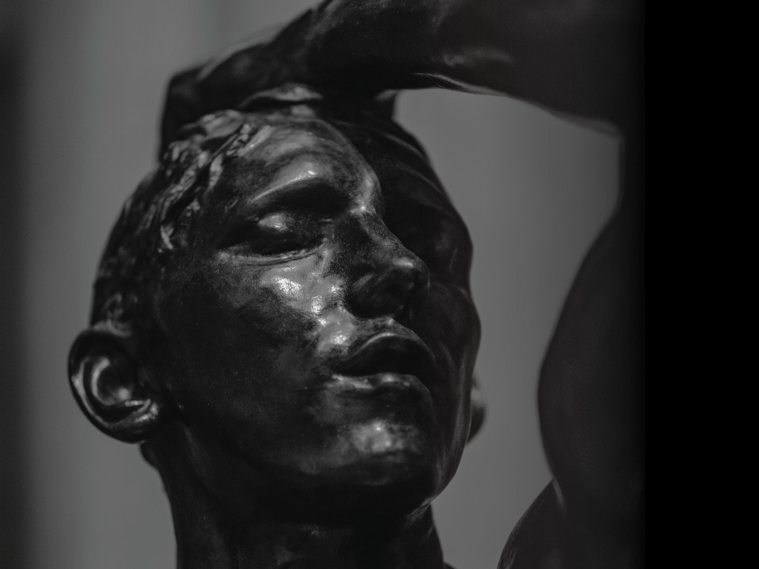 A black and white sculpture showing a man thinking